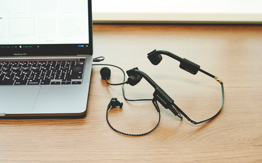 日本製の城下工業 SOUND WARRIORの折り畳み式ヘッドセットSW-HW1がノートパソコンとともに机の上にある