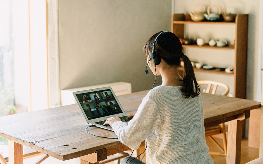 城下工業SOUND WARRIOR軽量片耳ヘッドセットSW-H1を女性が装着しノートパソコンでオンライン会議をしている