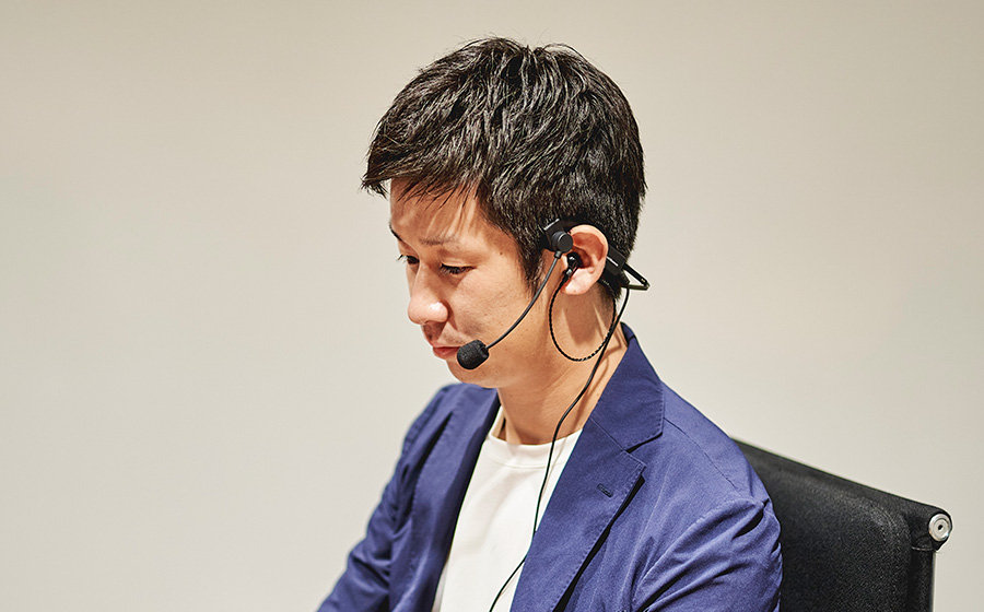 ブルーのジャケットを着用の男性が城下工業SOUND WARRIOR折りたたみ式ヘッドセットを着けている