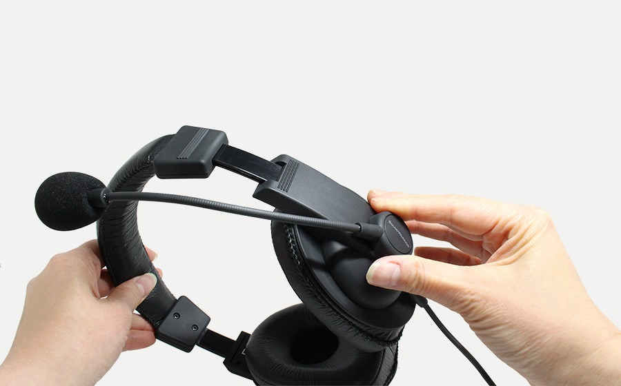 城下工業SOUND WARRIOR日本製密閉型オーバーイヤーSW-TR2ヘッドセットを両手でもってマイクブームを動かしている