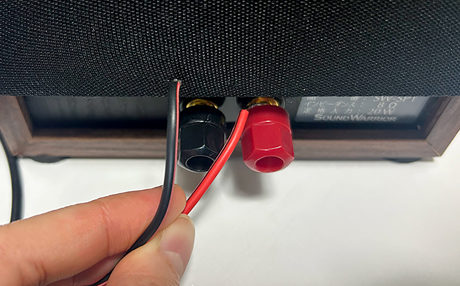 スピーカーにスピーカーケーブルを接続するところ