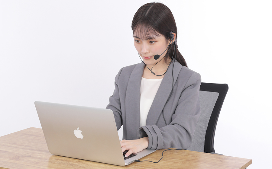 女性が城下工業SOUND WARRIOR折りたたみ式ヘッドセットを着けてパソコン作業をしている